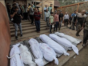People mourn as they collect the bodies of Palestinians killed in Israeli raids on Nov. 13, 2023 in Khan Yunis, Gaza.