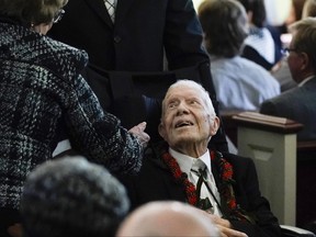 Former U.S. president Jimmy Carter departs a funeral service.