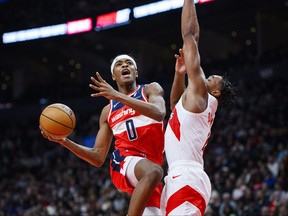Washington Wizards guard Bilal Coulibaly (0) goes up for a lay up while defended by Toronto Raptors forward Scottie Barnes (4) during first half in Toronto on Monday, Nov. 13, 2023.