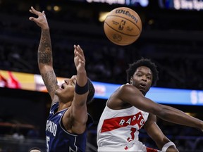 Raptors' O.G. Anunoby (right) blocks a shot by Orlando Magic's Paolo Banchero during the first half on Tuesday, Nov. 21, 2023, in Orlando, Fla.