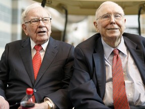 Berkshire Hathaway chairman and CEO Warren Buffett, left, and vice-chairman Charlie Munger, briefly chat with reporters May 3, 2019, one day before Berkshire Hathaway's annual shareholders meeting in Omaha, Neb.