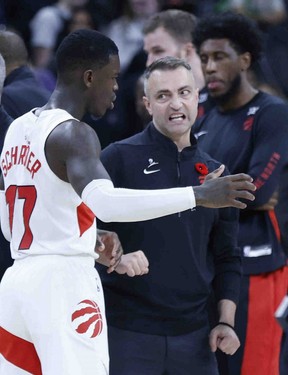 Dennis Schroder, left, talks with new Raptors head coach Darko Rajakovic during Sunday’s game against the San Antonio Spurs. Ronald Cortes/Getty Images