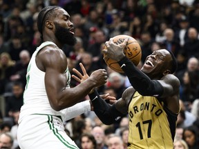 Raptors guard Dennis Schroder (right) is pressured by Celtics guard Jaylen Brown (left) during first half NBA action in Toronto, Friday, Nov. 17, 2023.