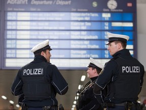 In this file photo taken on March 10, 2017, policemen stand under a schedule board of the main train station in Duesseldorf, western Germany, one day after German police arrested an axe-wielding attacker.
