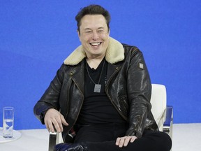Elon Musk smile against a blue background