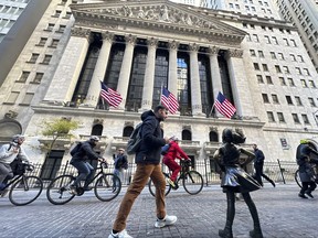 A man passes the "Fearless Girl" statue in front of the New York Stock Exchange in New York on Friday, Nov. 3, 2023.