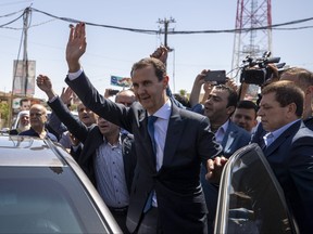 Syrian President Bashar Assad waves to his supporters.