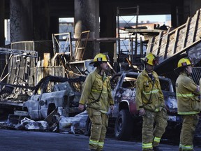 Los Angeles firefighters assess the damage from an intense fire under Interstate 10.