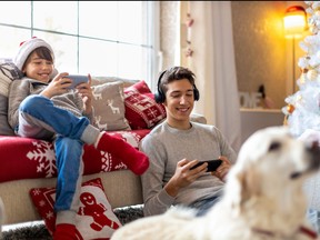 Two brothers using gaming devices on Christmas Eve