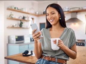 A smiling woman looks at her phone