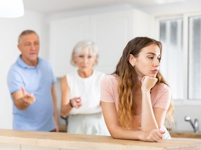Upset adult daughter happens to reproach parents in the kitchen