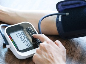 Man checks blood pressure monitor and heart rate monitor.