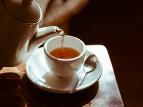 Tea cup on saucer, with tea being poured,