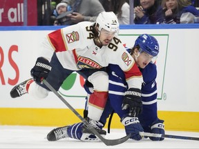 Florida Panthers left-winger Ryan Lomberg and Toronto Maple Leafs left-winger Matthew Knies battle for the puck.