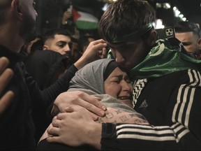 Omar Atshan, 17, is hugged by his mother after being released from an Israeli prison in the West Bank town of Ramallah, Sunday Nov. 26, 2023.
