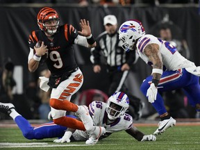 Cincinnati Bengals quarterback Joe Burrow, left, runs with the ball as Buffalo Bills defensive end Leonard Floyd, bottom, and safety Taylor Rapp try to stop him during the second half of an NFL football game, Sunday, Nov. 5, 2023, in Cincinnati.