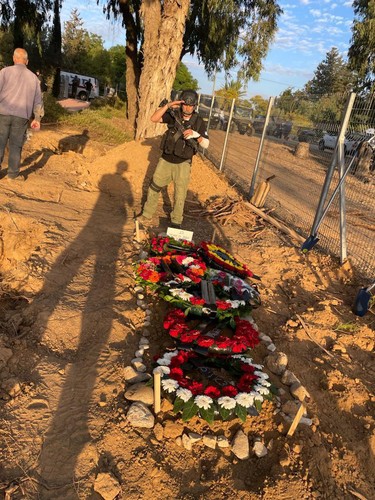 Harel Oren salutes at a memorial.