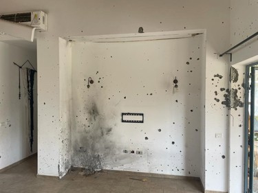 Bullet holes and blast marks riddle a living room.