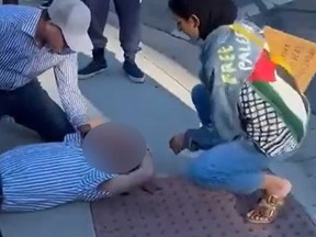 A Jewish man lies on the ground after allegedly being hit by a protester in a Los Angeles suburb.