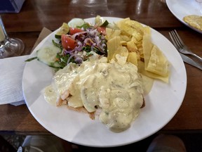 A plate of fish served with white sauce, salad and plantain chips. It’s one of the many offerings on the Los Defines menu. (EDDIE CHAU/Toronto Sun)