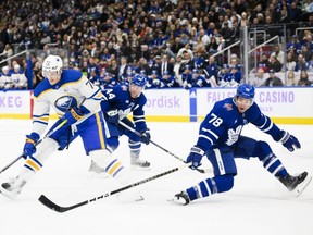 Sabres right wing Tage Thompson (left) is defended by Maple Leafs defenceman TJ Brodie (right) and defenceman Morgan Rielly (centre) during first period NHL action in Toronto, Saturday, Nov. 4, 2023.