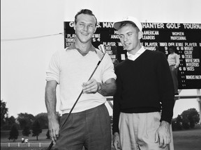 Arnold Palmer, left, 24, of Cleveland, Ohio, holds a 2-iron and talks with Eddie Merrins of Meridan, Miss., after Palmer won the All-American amateur golf tournament, Aug. 8, 1954, at Chicago's Tam O'Shanter club.