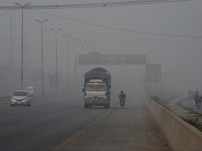 Vehicles move on a highway as smog envelops the areas of Lahore, Pakistan, Wednesday, Nov. 8, 2023.