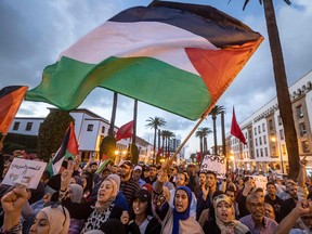 Moroccans wave the Palestinian flag during a gathering
