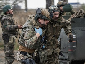 A Ukrainian military man is helped