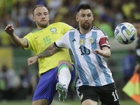 Argentina's Lionel Messi, right, and Brazil's Carlos Augusto battle for the ball during a qualifying soccer match for the FIFA World Cup 2026 at Maracana stadium in Rio de Janeiro, Brazil, Tuesday, Nov. 21, 2023.