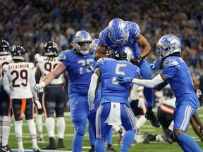 Detroit Lions wide receiver Amon-Ra St. Brown (14) jumps on running back David Montgomery (5) after Montgomery's 1-yard rushing touchdown during the second half of an NFL football game against the Chicago Bears, Sunday, Nov. 19, 2023, in Detroit.