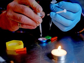 A man prepares an injection of fentanyl at a supervised consumption site in Vancouver. Photographer: Gary Coronado/Los Angeles Times/Getty Images