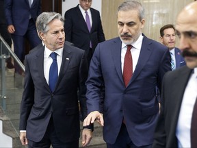 U.S. Secretary of State Antony Blinken, left, walks with Turkish Foreign Minister Hakan Fidan, centre, after meeting with his Turkish counterpart at the Ministry of Foreign Affairs in Ankara, on Nov. 6, 2023.