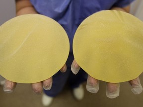 A nurse holds defective breast implants in Nice, southern France, Tuesday, Jan. 10, 2012. In Canada, the House of Commons health committee is echoing long-standing calls from plastic surgeons and patient advocates for a national breast implant registry to prevent illness and problems linked to the medical devices.