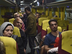 Palestinians with Canadian passports who were evacuated from Gaza sit in a bus at the Rafah border crossing in Egypt, late Sunday, Nov. 12, 2023.