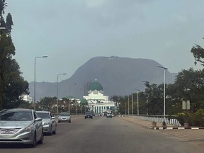 Cars drive past the National Assembly building in Abuja, Nigeria, Thursday, Nov. 2, 2023.
