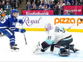 Toronto Maple Leafs' Mitchell Marner scores against Seattle Kraken goaltender Philipp Grubauer.