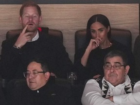 Prince Harry, back left, and Meghan Markle, back right, at the Vancouver Canucks game Nov. 20, 2023.