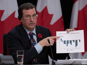 Commissioner of the Environment and Sustainable Development Jerry DeMarco holds a chart showing Canada's performance against G7 countries in reducing greenhouse gas emissions during a news conference Tuesday, Nov. 7, 2023, in Ottawa.