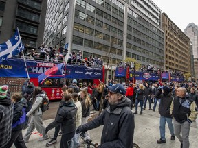 Fans walk along and cheer with the Montreal Alouettes during the Grey Cup victory parade in Montreal on Wednesday, Nov. 22, 2023. Some dreary November weather didn't stop fans from turning up in numbers at the parade on Wednesday.