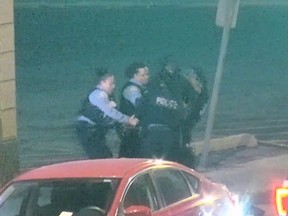 Screengrab of four Chicago police officers struggling to detain suspected shoplifter.