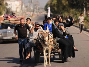 Palestinians fleeing Gaza City towards the southern areas ride on a road on Nov. 7, 2023, amid the ongoing battles between Israel and the Palestinian Islamist group Hamas.