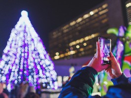 Person taking photo of Christmas tree.