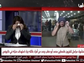 Palestine TV correspondent Salman Al-Bashir, right, removing his flak jacket