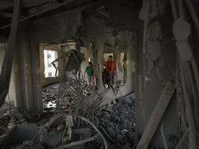 Palestinians look at the apartment of Khaled Kharousha