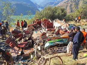 Security personnel and rescue workers gather beside the wrecked bus, subject to an accident on a remote mountain road in the Doda area, about 200 kilometres southeast of the Srinagar on Nov. 15, 2023.