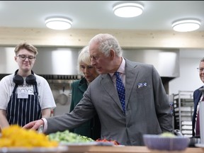King Charles III and Queen Camilla meet staff in the kitchen during the launch of the Coronation Food Project and the visit to the South Oxfordshire Food and Education Alliance, a surplus food distribution centre, on Nov. 14, 2023 in Didcot, England.