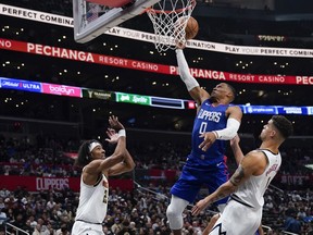 Los Angeles Clippers guard Russell Westbrook, center, shoots against Denver Nuggets forwards Zeke Nnaji, left, and Michael Porter Jr. during the second half of an NBA basketball game, Monday, Nov. 27, 2023, in Los Angeles.