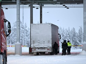 Border guards and a customs official check a truck at the Raja-Jooseppi international border crossing station in Inari, northern Finland on Nov. 28, 2023.