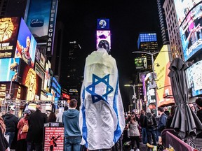 A protester wrapped in an Israeli flag during a rally for the release of hostages in Gaza held by Hamas operatives in New York City's Times Square, Oct. 19, 2023.